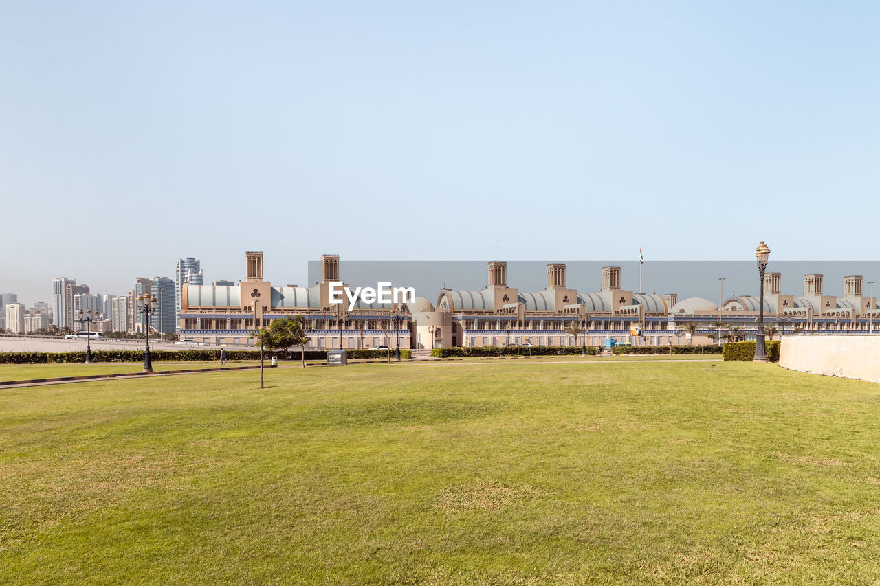 architecture, sky, built structure, horizon, building exterior, grass, nature, skyline, clear sky, travel destinations, city, building, copy space, landscape, urban skyline, day, walkway, travel, no people, water, tourism, cityscape, landmark, plant, outdoors, sunny, land, history, the past