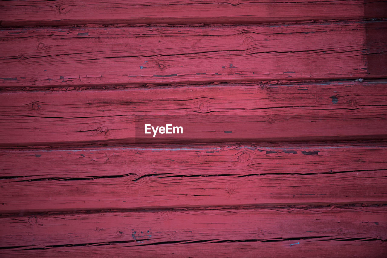 FULL FRAME SHOT OF RED WOOD ON WOODEN SURFACE