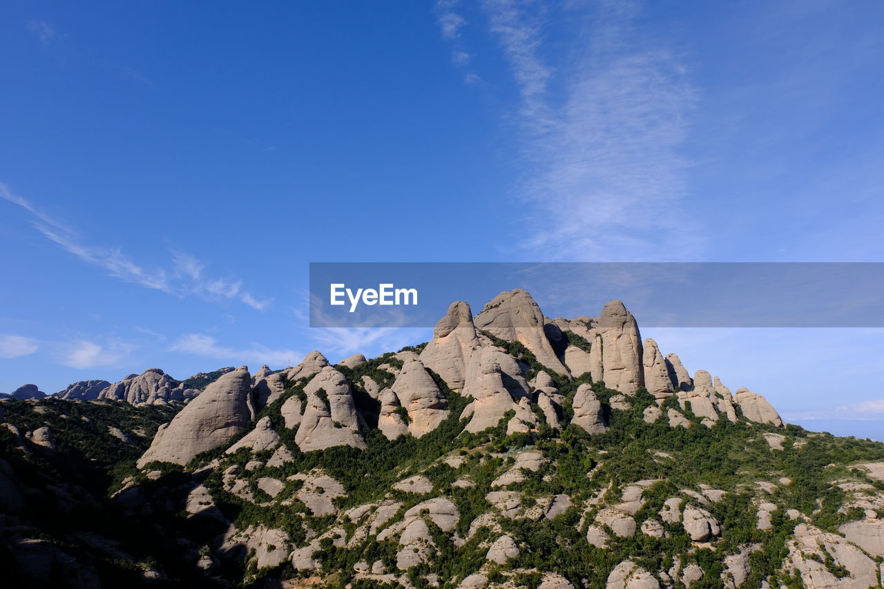 Scenic view of rocky mountains against blue sky