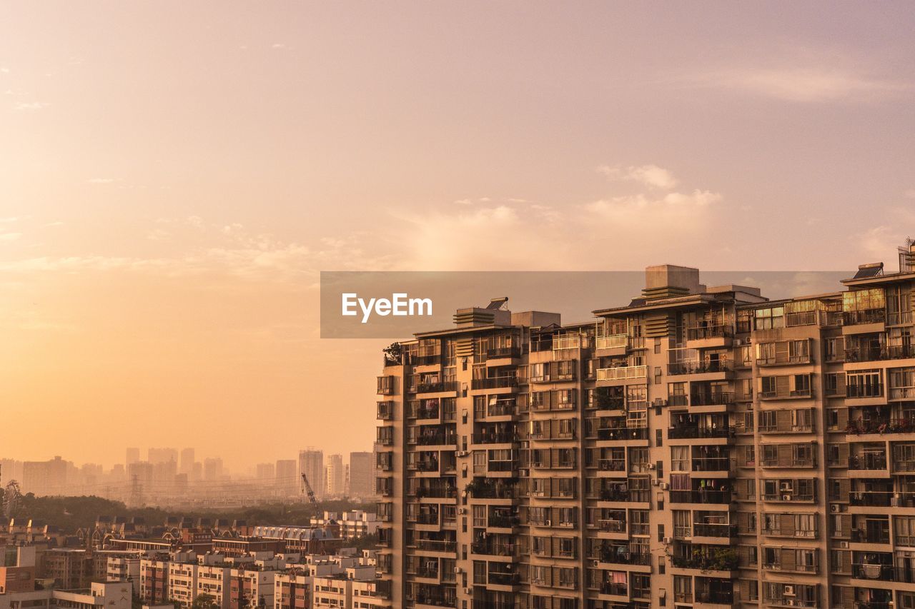 Buildings in city against sky during sunset
