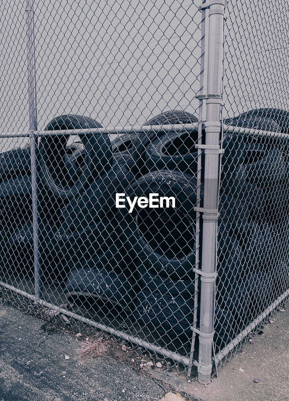 Heap of tires seen through chainlink fence