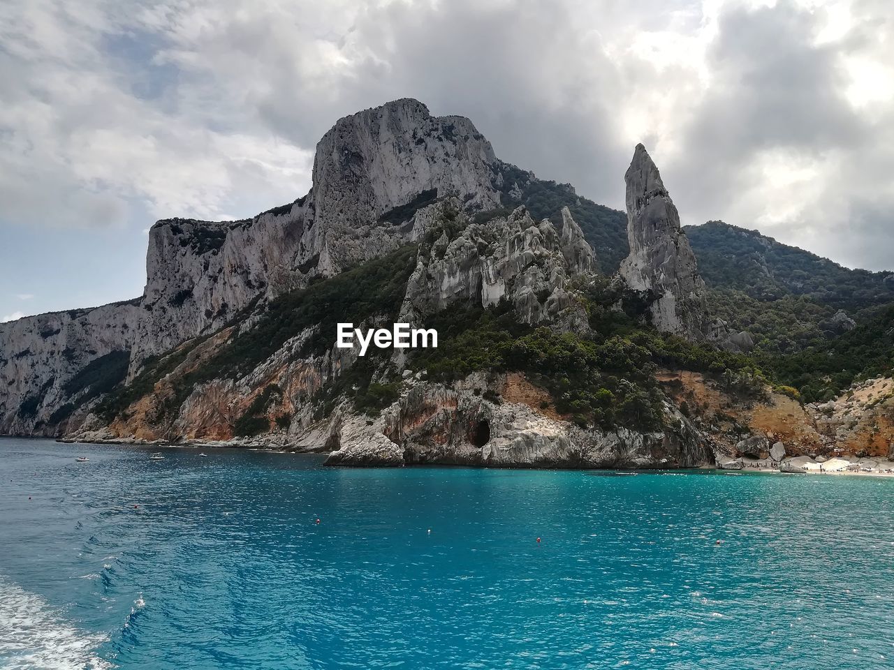 Scenic view of sea by rock formation against sky