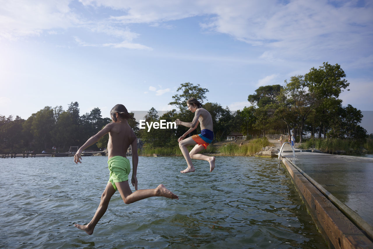 Boys jumping into water