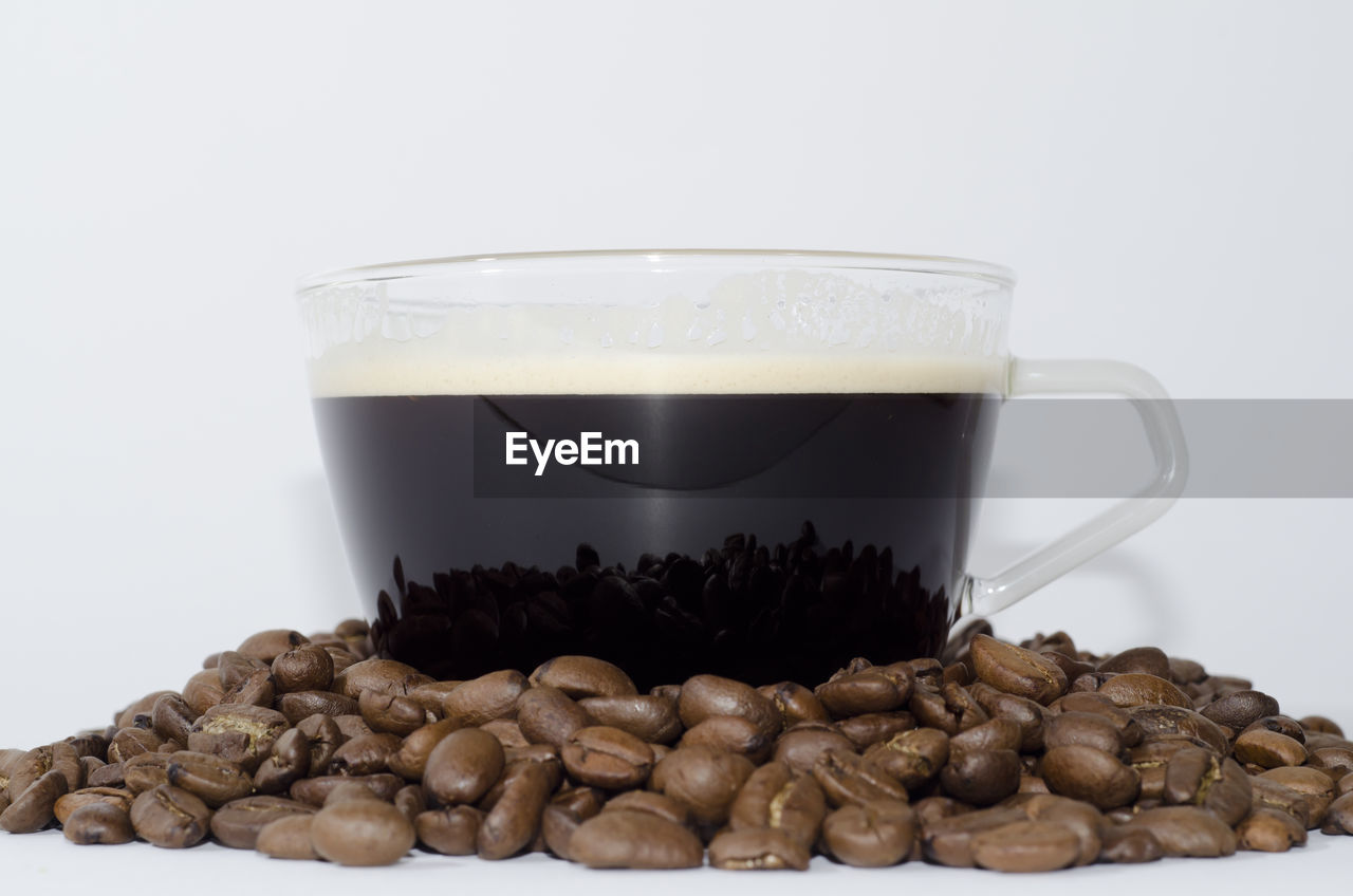 Close-up of coffee cup on table against white background