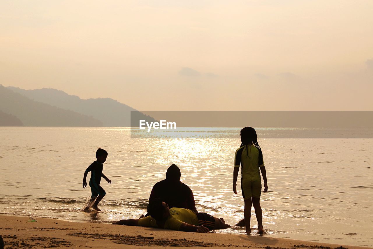 PEOPLE AT BEACH DURING SUNSET