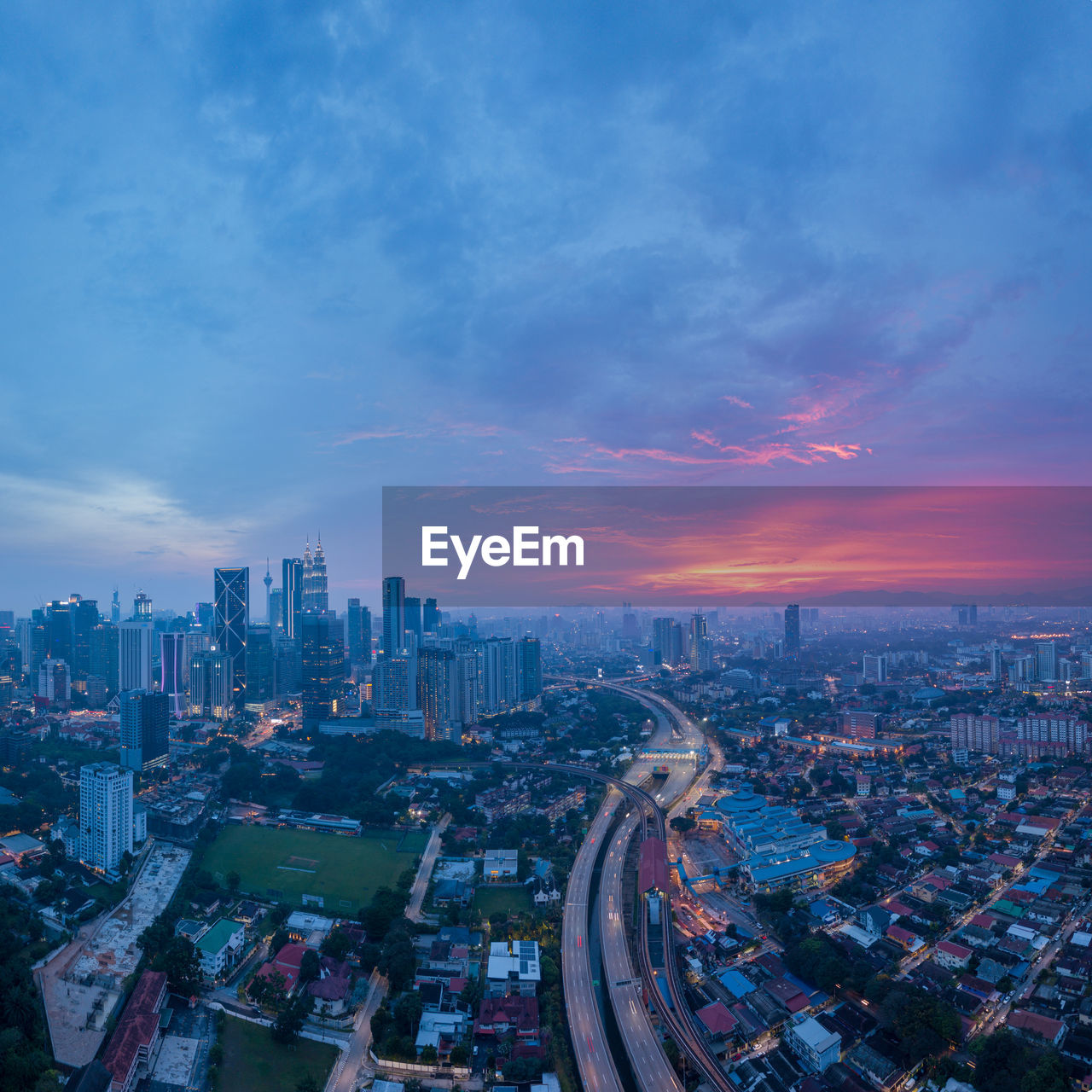 High angle view of illuminated buildings against sky at dusk