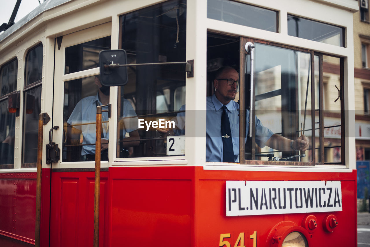 FULL LENGTH PORTRAIT OF YOUNG MAN ON BUS