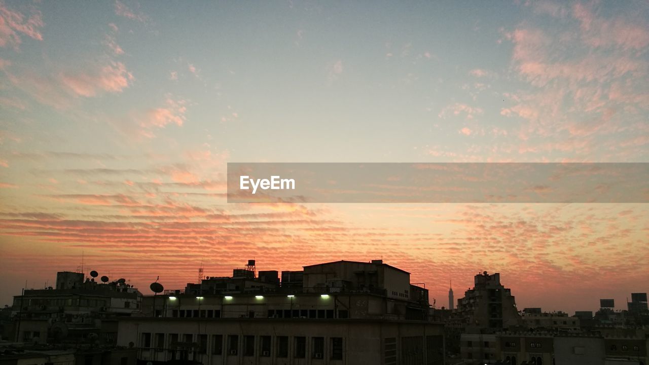 LOW ANGLE VIEW OF SILHOUETTE BUILDINGS AGAINST SKY