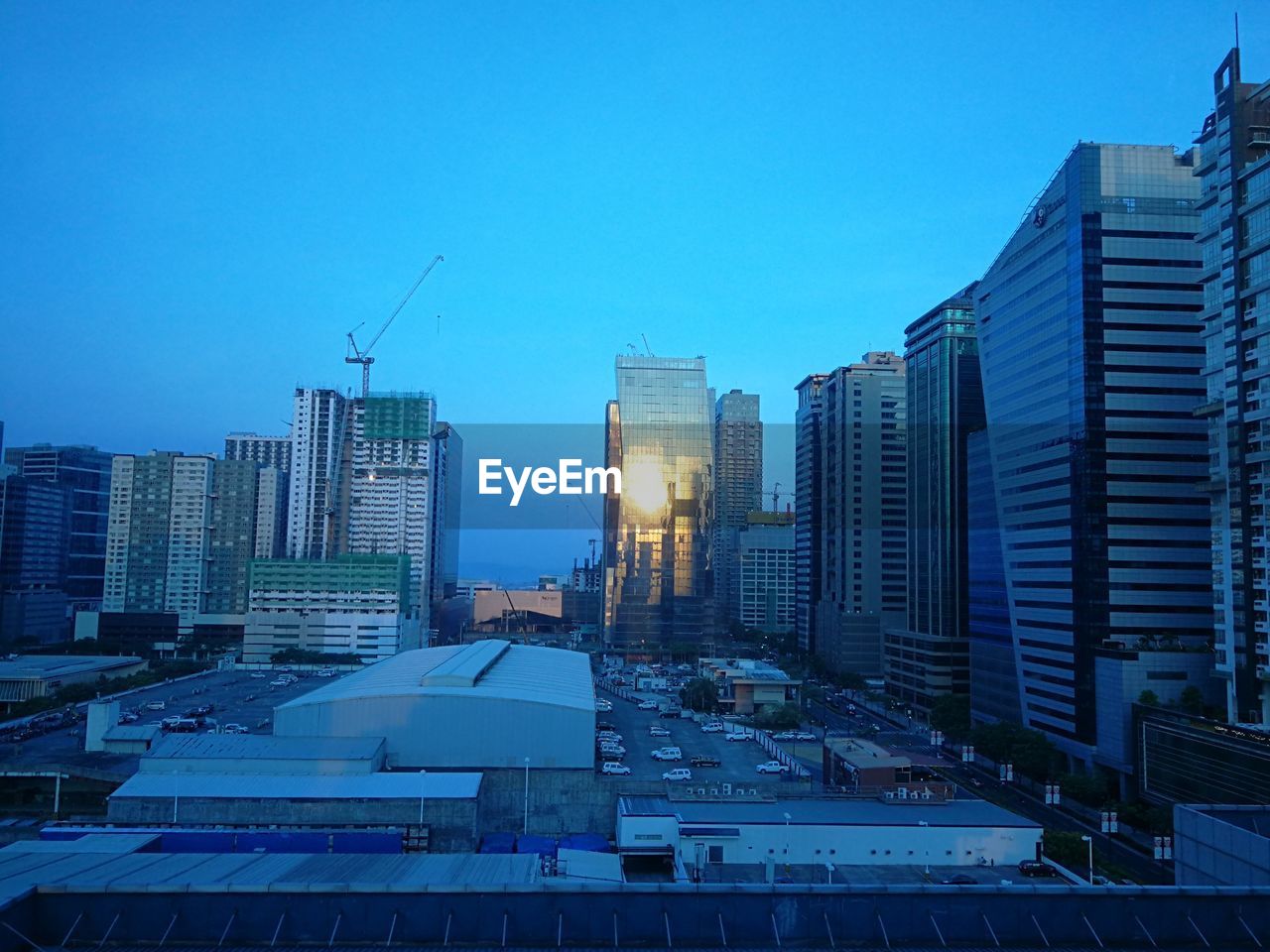 Modern buildings in city against clear blue sky