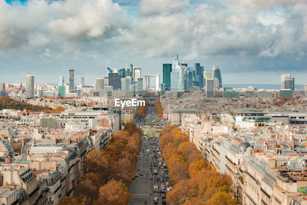 Aerial view of city buildings against cloudy sky