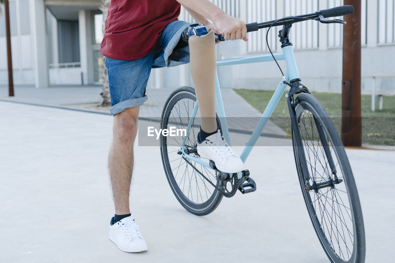 Disabled man riding bicycle on street