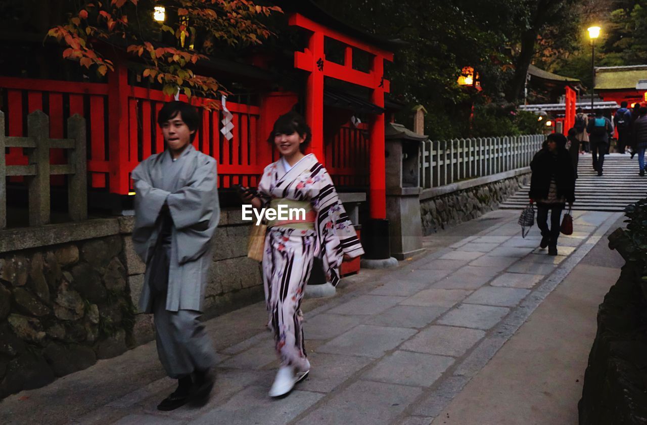 FULL LENGTH OF WOMAN STANDING IN ILLUMINATED PARK