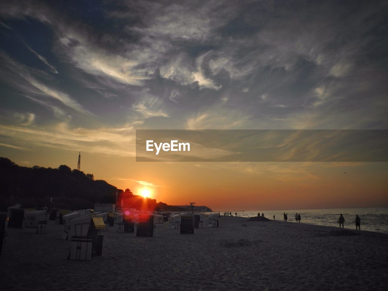 Wicker deck chairs on beach against sunset sky in usedom