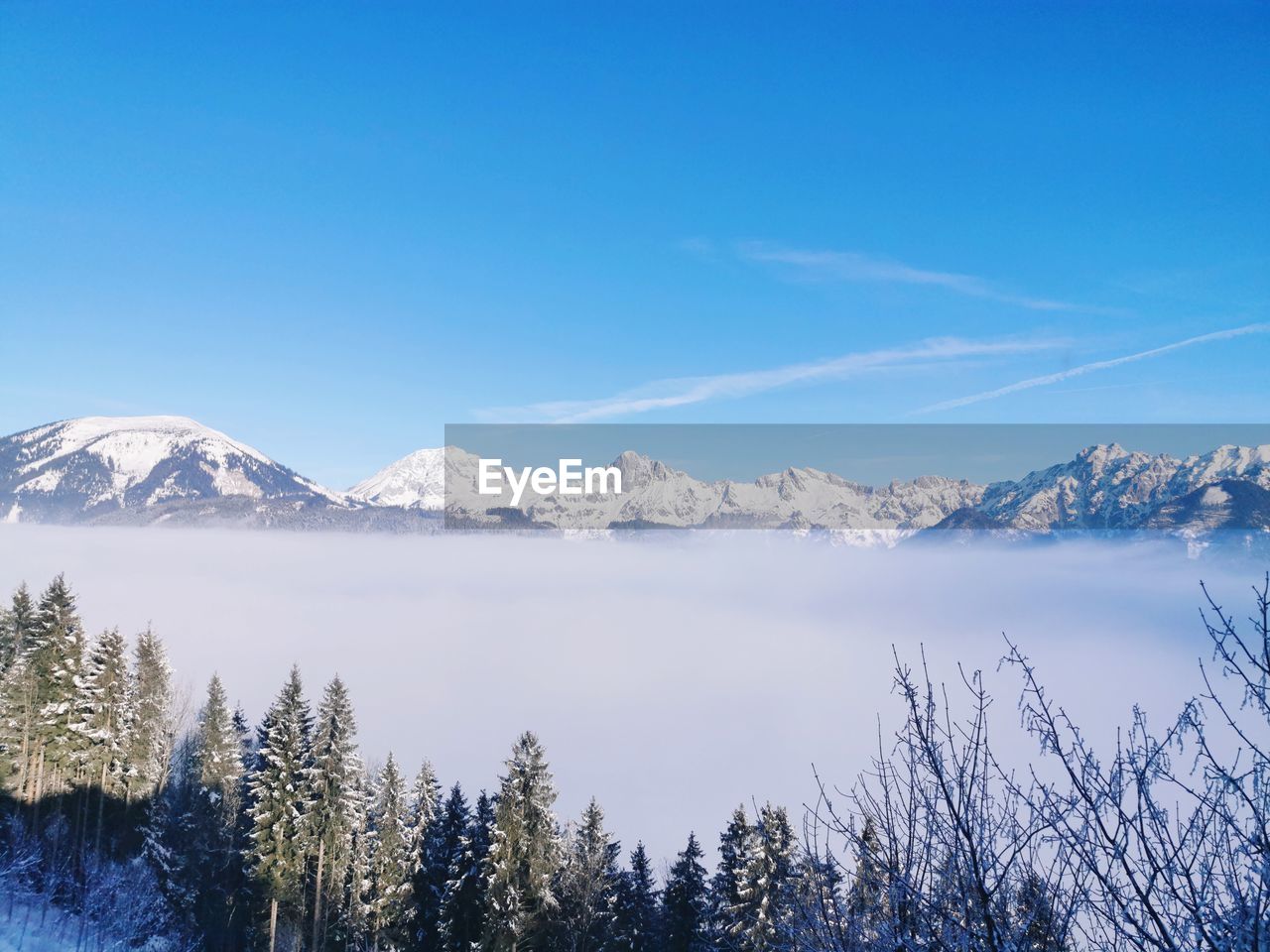 Scenic view of snowcapped mountains against blue sky