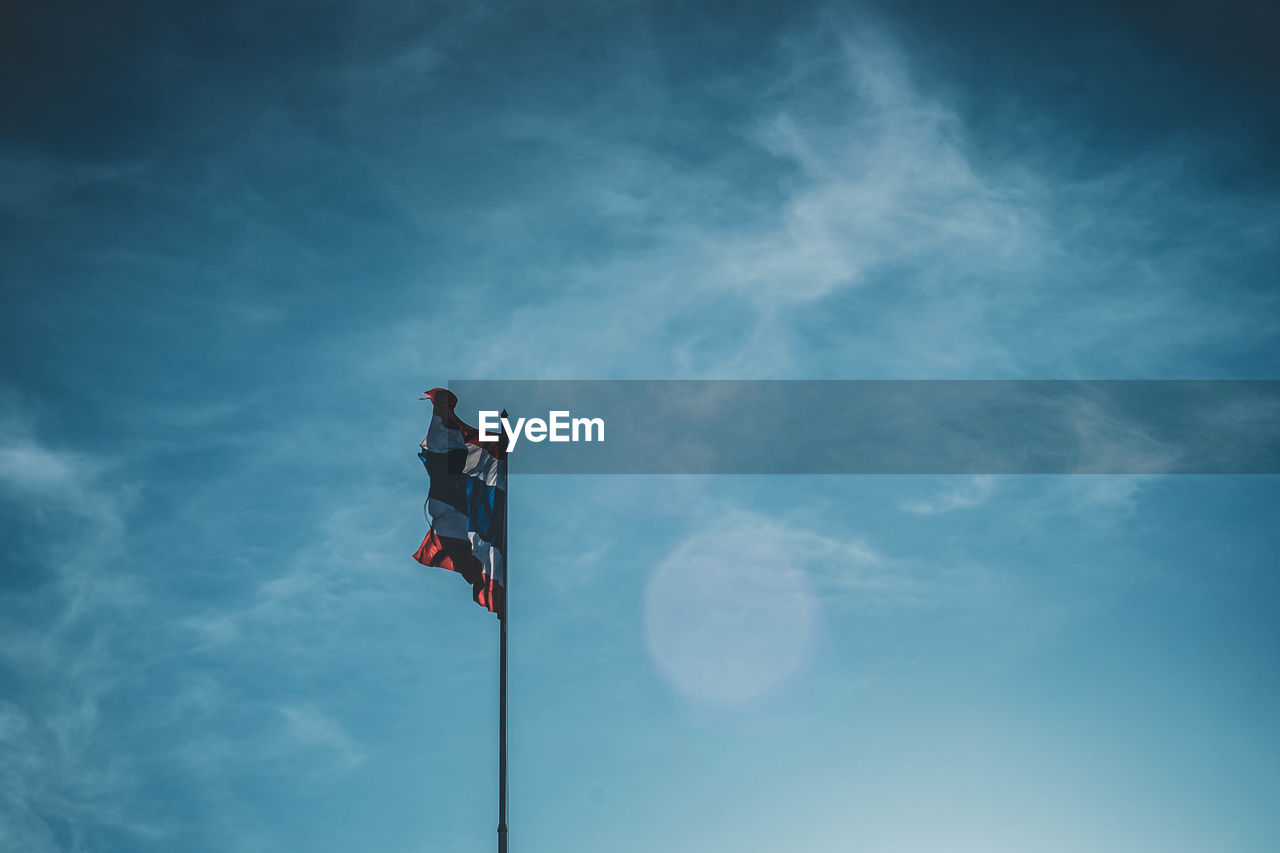 Low angle view of flag against blue sky