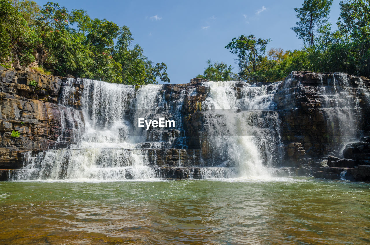 Low angle view of saala waterfall in forest against sky, guinea, west africa