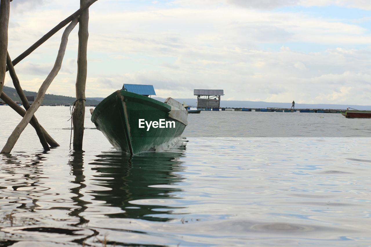 BOAT MOORED ON SEA AGAINST SKY