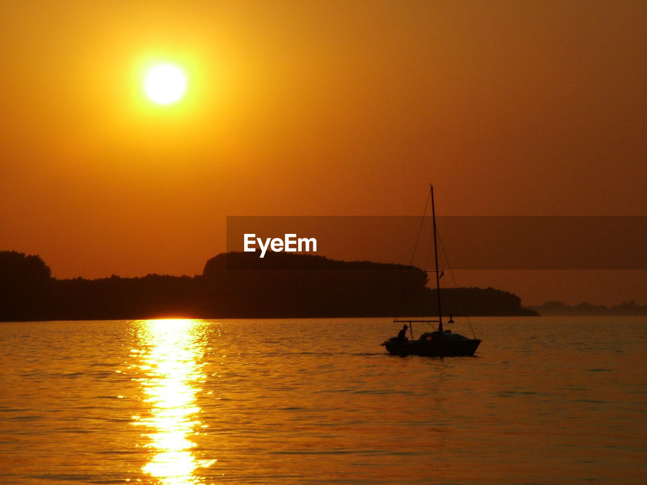SILHOUETTE SAILBOAT IN SEA AGAINST ORANGE SKY