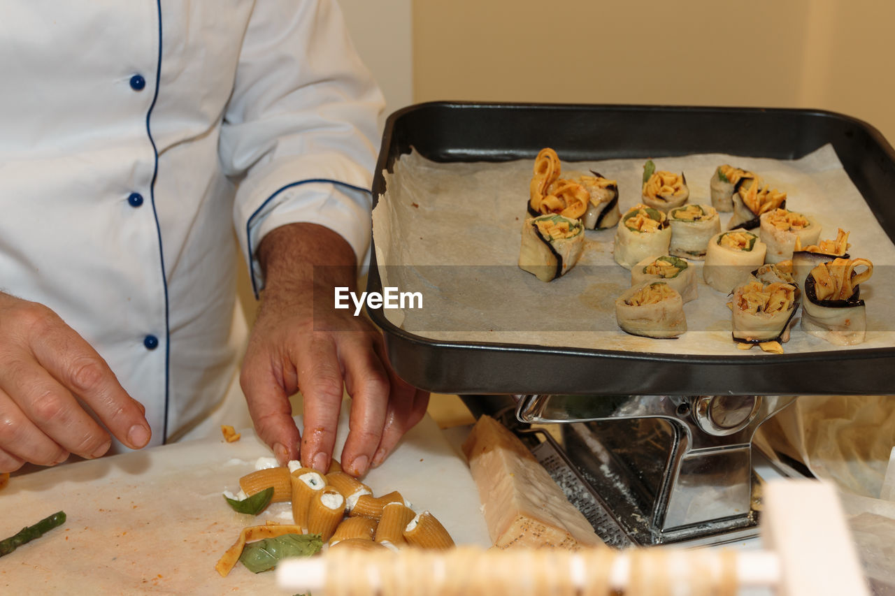 MIDSECTION OF MAN HAVING FOOD IN KITCHEN