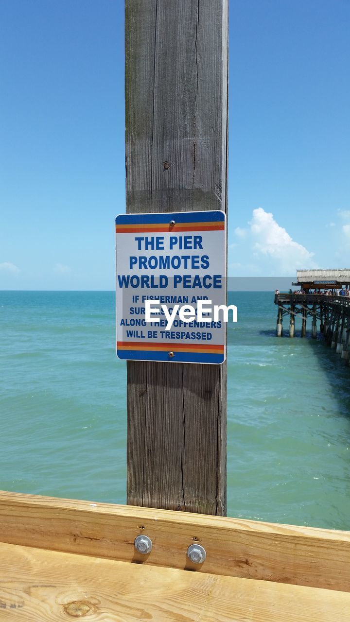 INFORMATION SIGN ON BEACH AGAINST CLEAR SKY