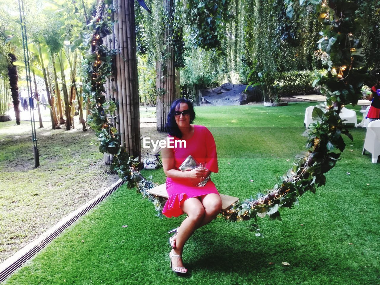 Full length of woman sitting on swing at park