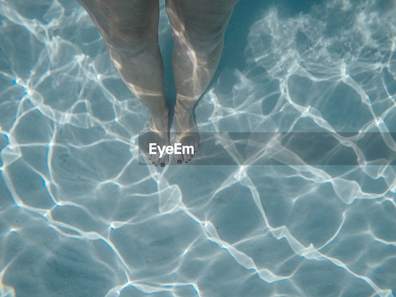 LOW SECTION OF PERSON SWIMMING IN SEA