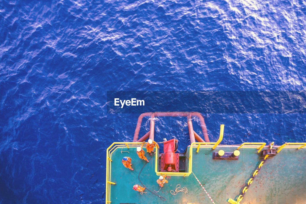 Directly above shot of workers on barge in sea