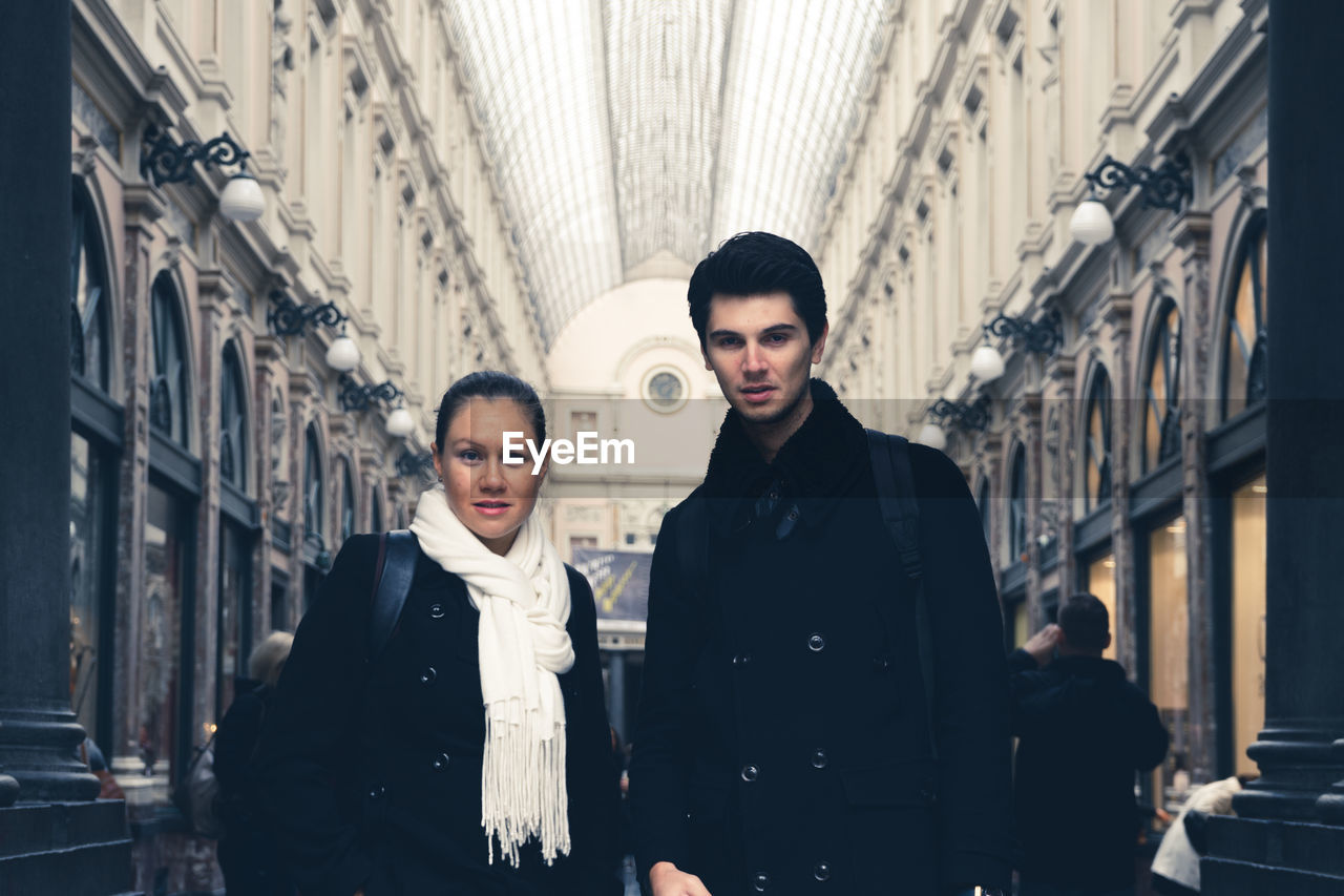 Portrait of couple standing at les galeries royales saint-hubert