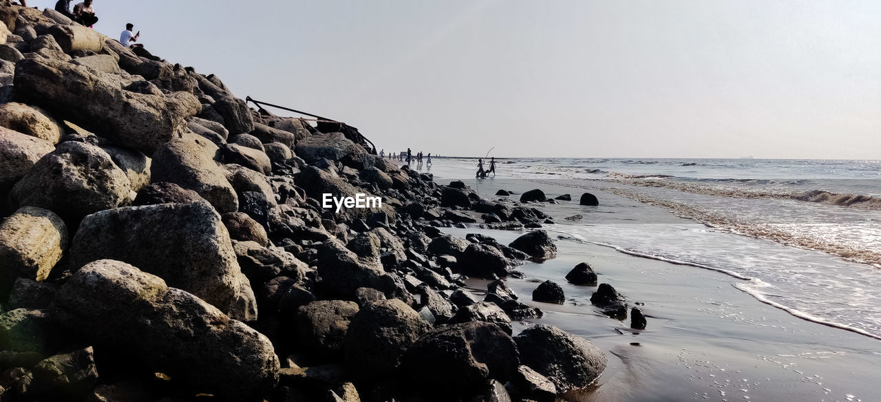 Rock formation on beach against clear sky