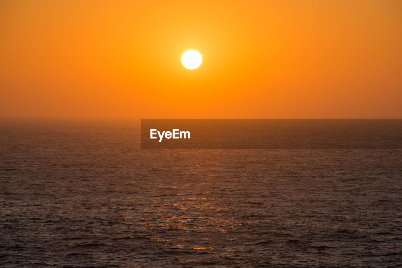 Scenic view of sea against orange sky