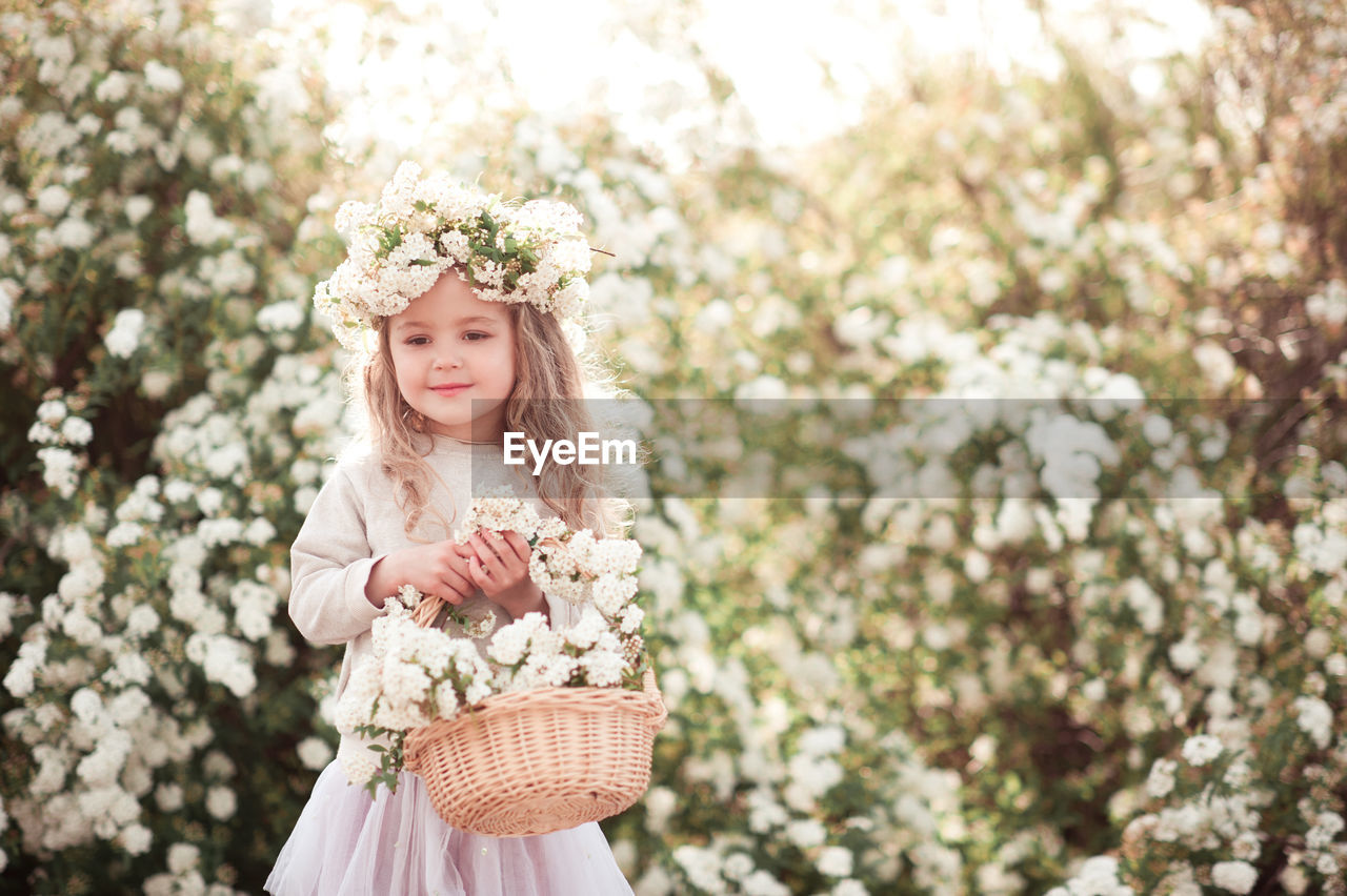 flower, spring, plant, flowering plant, women, one person, nature, clothing, beauty in nature, fashion, hairstyle, dress, blossom, portrait, child, blond hair, adult, childhood, freshness, tree, happiness, long hair, smiling, female, young adult, bride, springtime, looking, front view, outdoors, emotion, wreath, pink, standing, day, lifestyles, celebration, white, crown, cherry blossom, innocence, three quarter length, cute, fragility, looking at camera, flower arrangement, laurel wreath, royalty, retro styled, elegance, bouquet