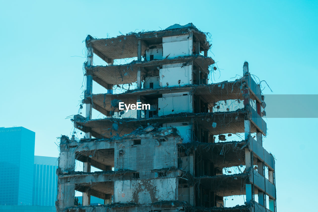 Low angle view of partly demolished building against sky