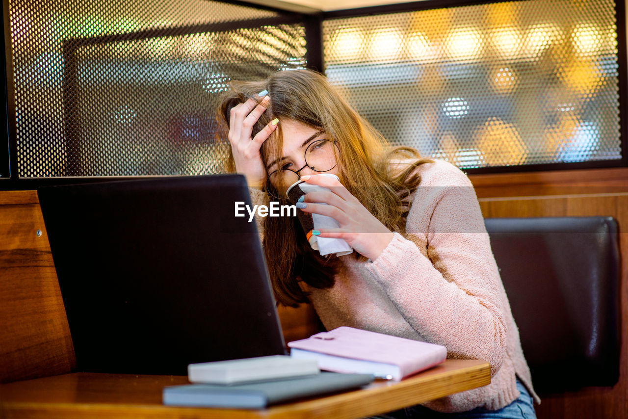 LOW SECTION OF WOMAN USING LAPTOP