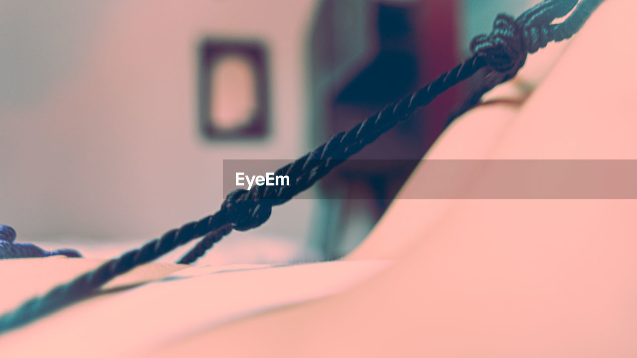 CLOSE-UP OF ROPE TIED TO WALL