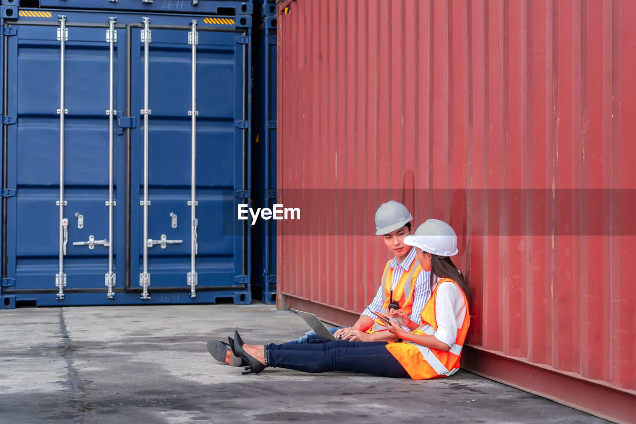 Engineers are overseeing the transportation of cargo with containers inside the warehouse.