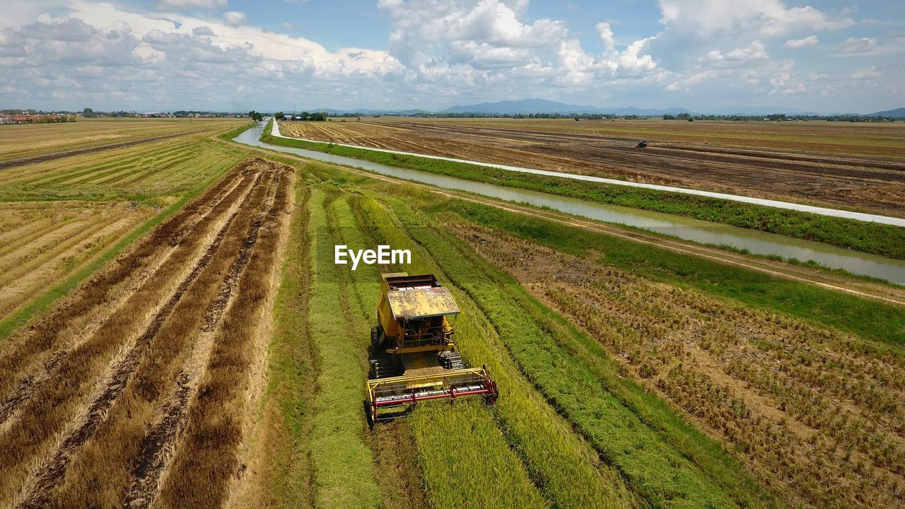 High angle view of combine harvester on agricultural field against sky