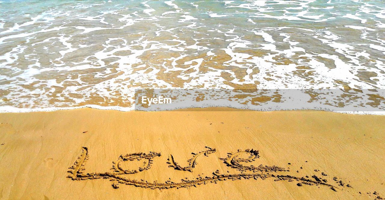 High angle view of love text at beach on sunny day