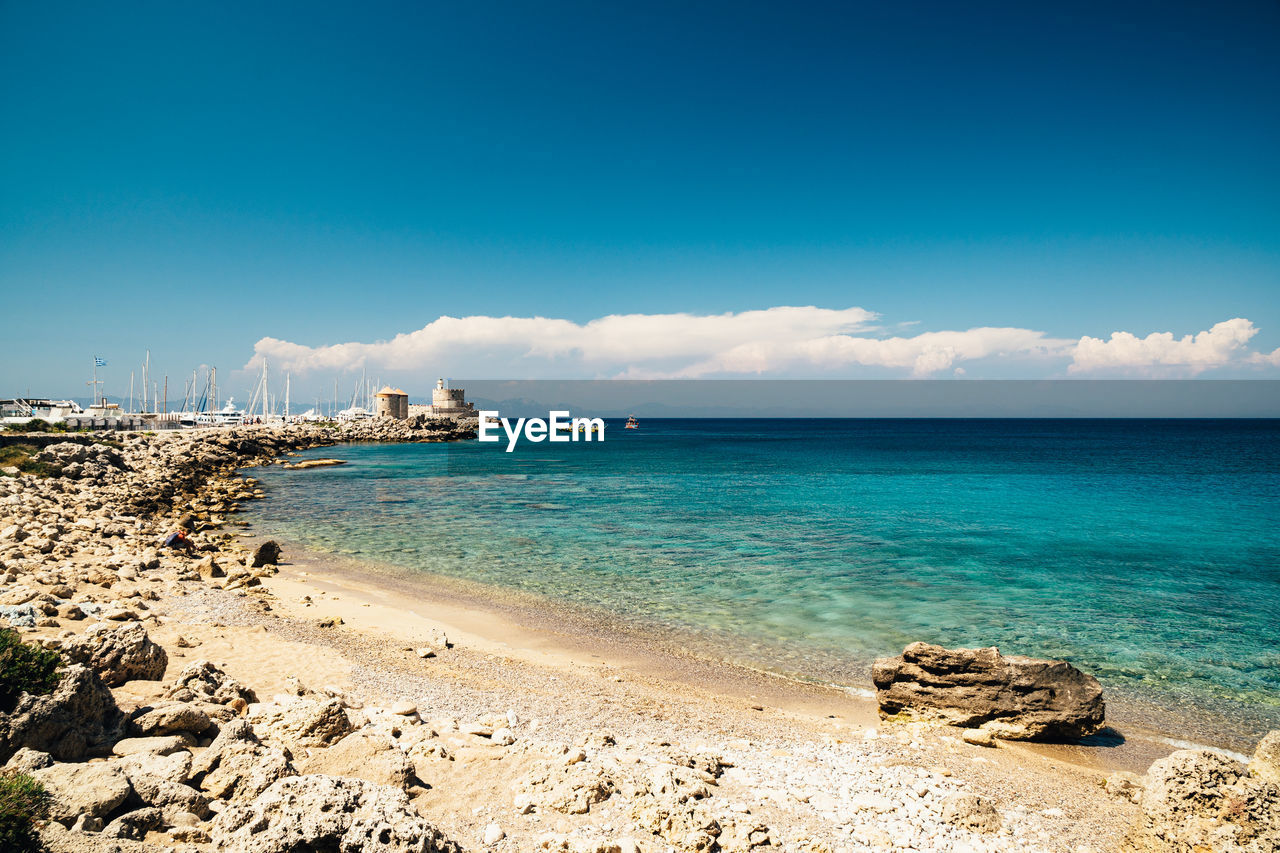 sea, water, land, sky, beach, body of water, horizon, ocean, shore, scenics - nature, beauty in nature, nature, coast, wave, travel destinations, travel, blue, sand, tranquility, environment, vacation, trip, holiday, cloud, tranquil scene, landscape, tourism, coastline, tropical climate, idyllic, island, horizon over water, no people, summer, outdoors, seascape, bay, rock, day, sunlight, wind wave, turquoise colored, lagoon, water's edge, sunny, arriving, motion, clear sky, relaxation, copy space, urban skyline