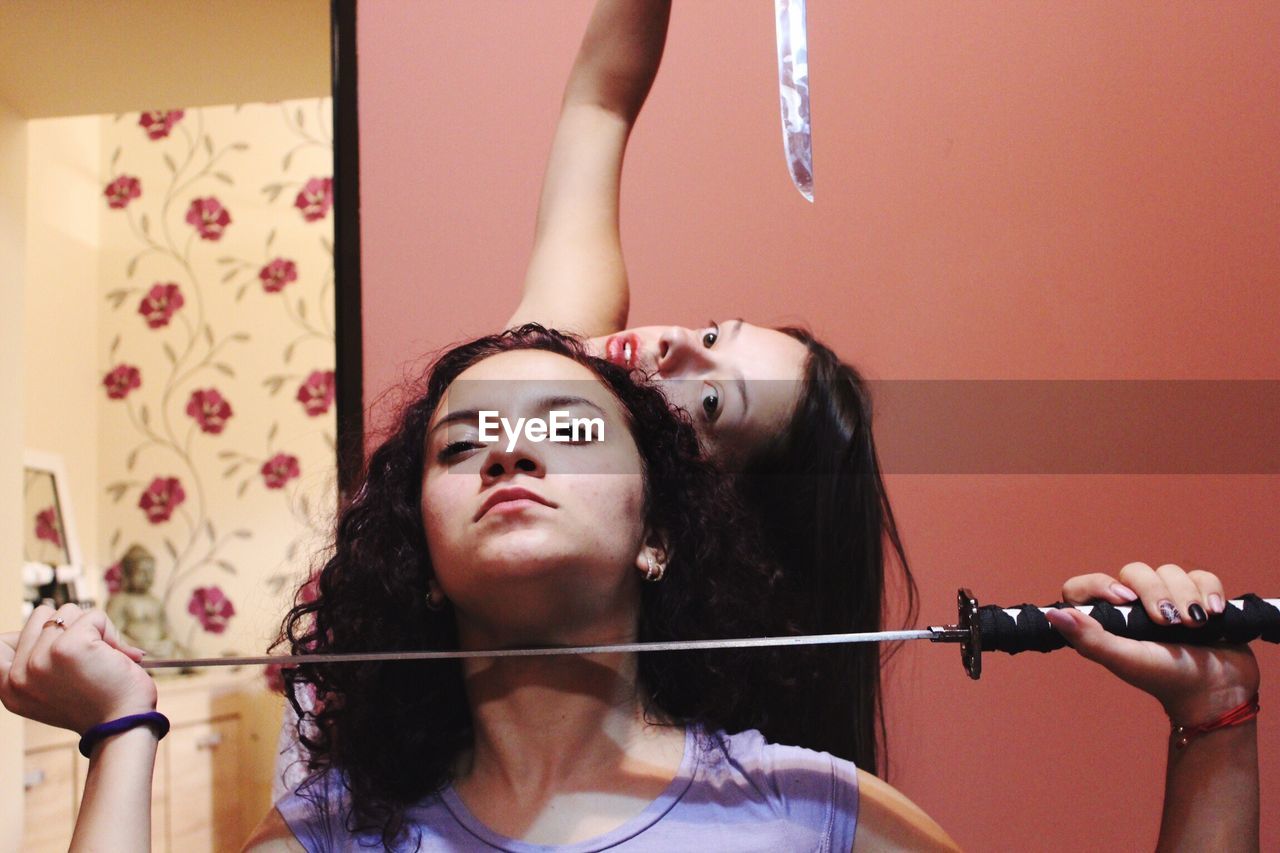 Portrait of friends holding swords while practicing for theatrical performance