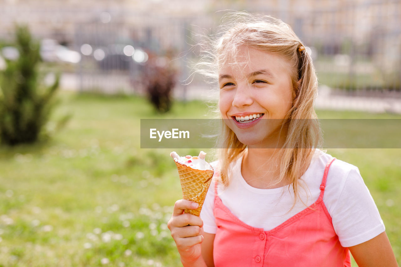 Portrait of smiling young woman holding ice cream