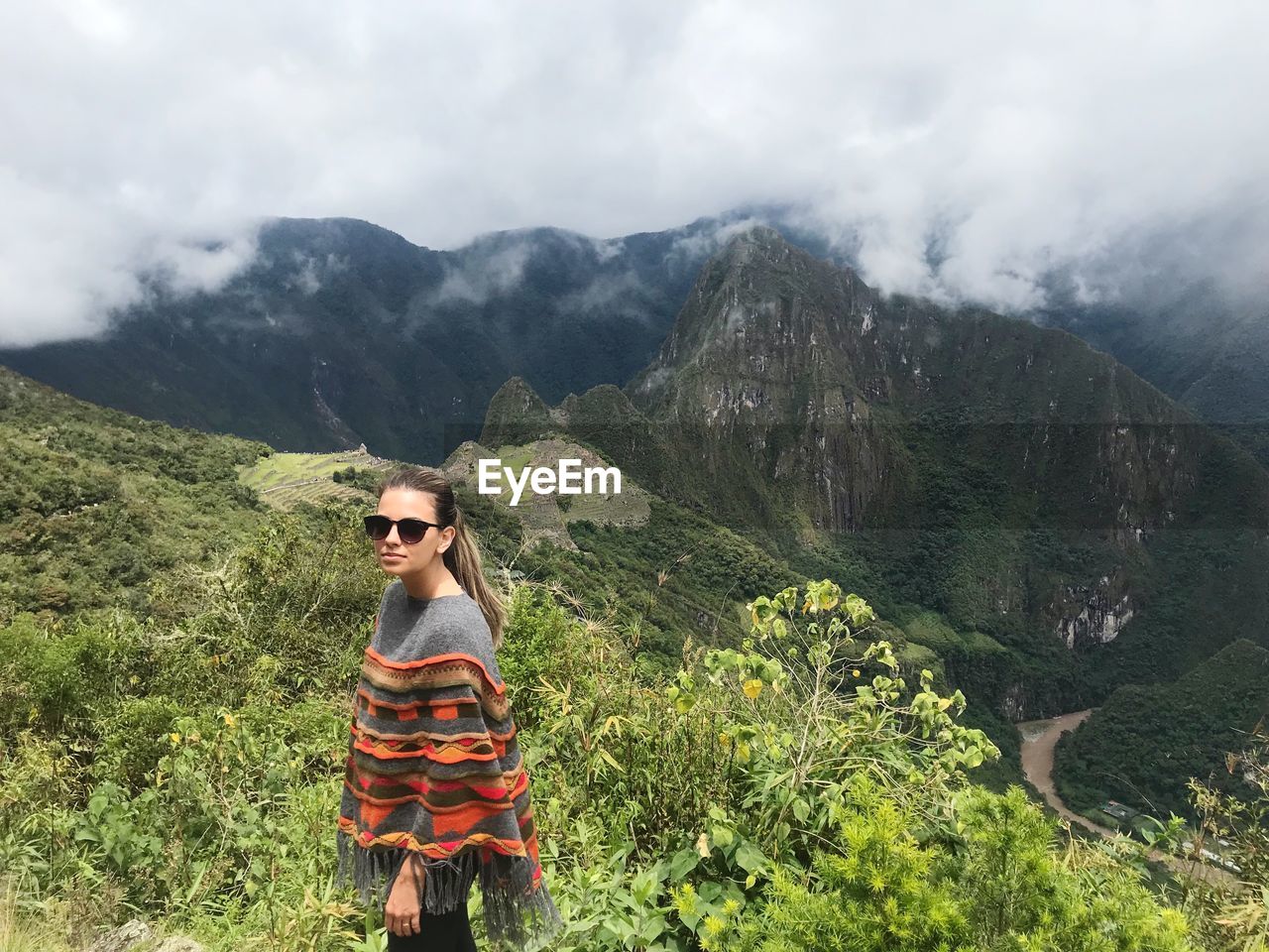 Woman wearing sunglasses while standing on mountain