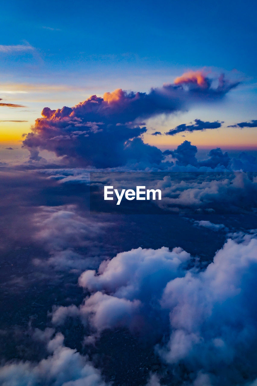 sky, cloud, environment, beauty in nature, nature, cloudscape, sunset, scenics - nature, horizon, blue, dramatic sky, aerial view, landscape, travel, tranquility, dawn, no people, outdoors, sun, idyllic, airplane, atmosphere, land, sunlight, tranquil scene, high up, air vehicle, moody sky, space, awe, mountain, afterglow, flying, high angle view, backgrounds, atmospheric mood, water