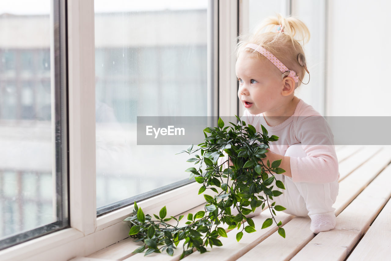 portrait of young woman looking through window