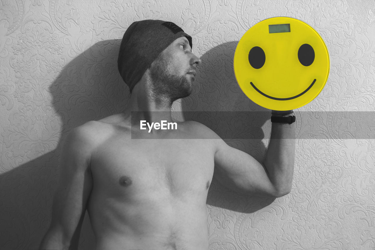 men, emoticon, smiley, one person, black and white, black, adult, human face, person, cartoon, wall - building feature, indoors, waist up, white, yellow, monochrome photography, muscular build, monochrome, lifestyles, smiling, facial hair, portrait, young adult, representation