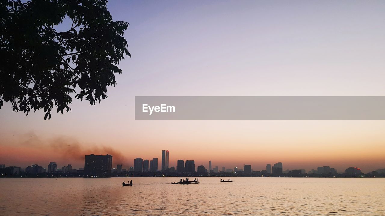 SILHOUETTE BUILDINGS AGAINST SKY DURING SUNSET