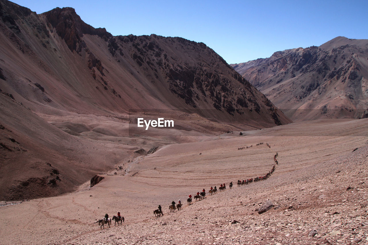 High angle view of people riding horses on mountain