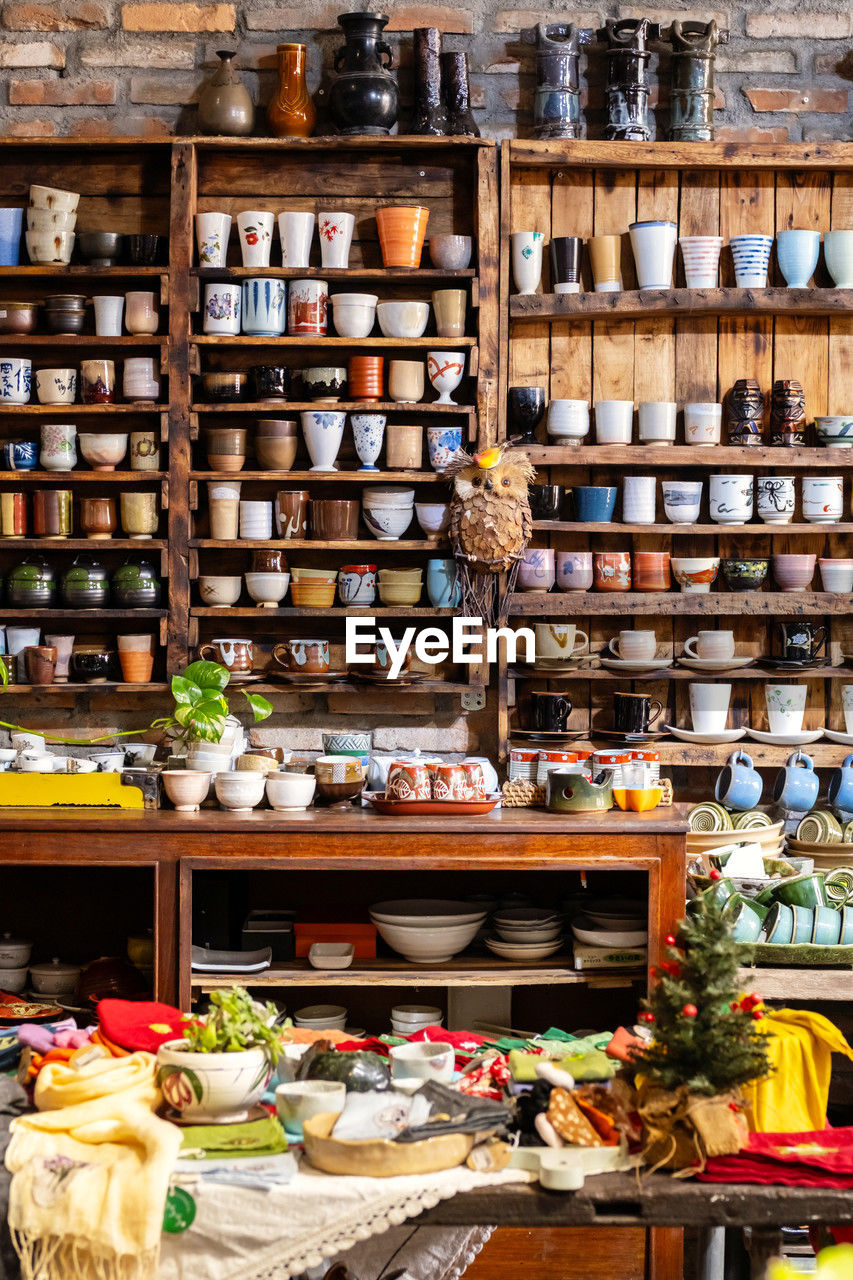 Small store with many pottery ceramic standing on shelves.