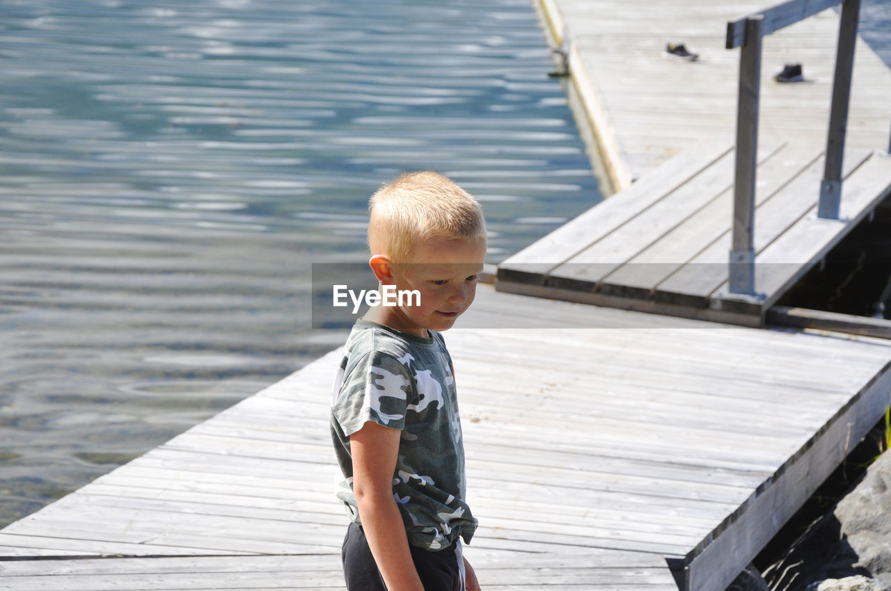 Boy standing on pier 