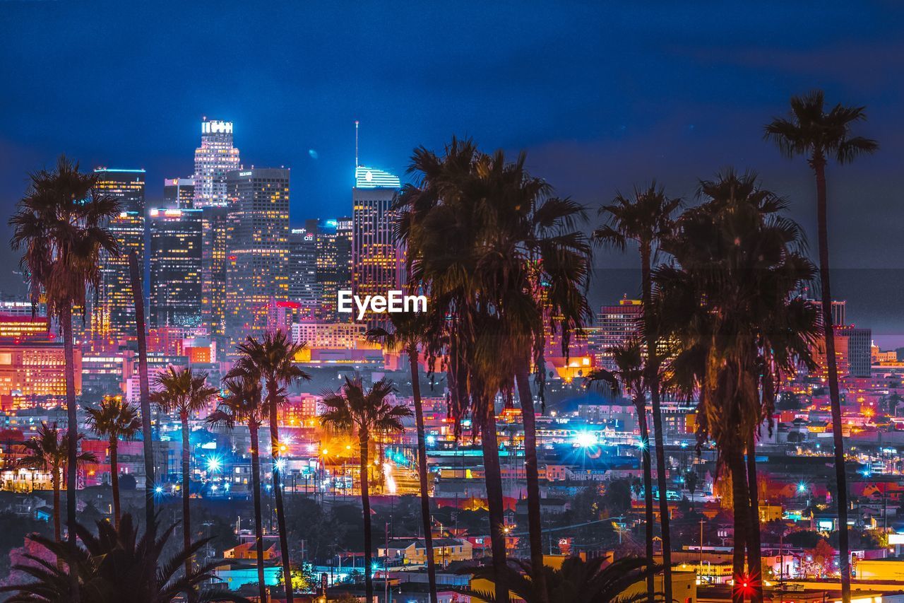 Illuminated city against sky at night