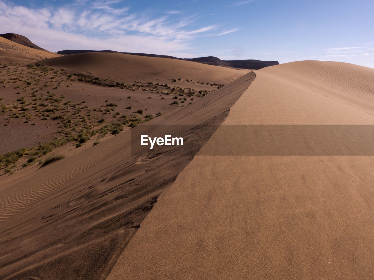 Sand dune in desert against sky